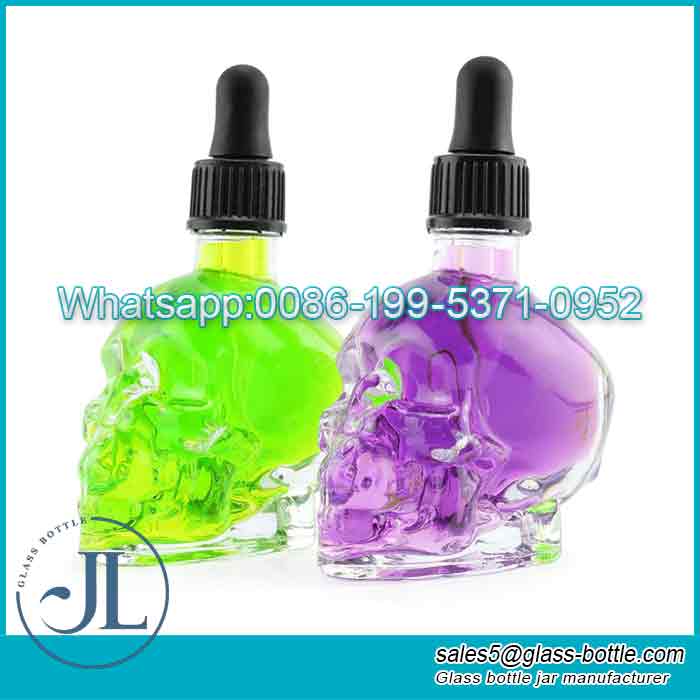 Proveedor personalizado de botellas cuentagotas de aceite esencial con cabeza de calavera de cristal de color de 30 ml